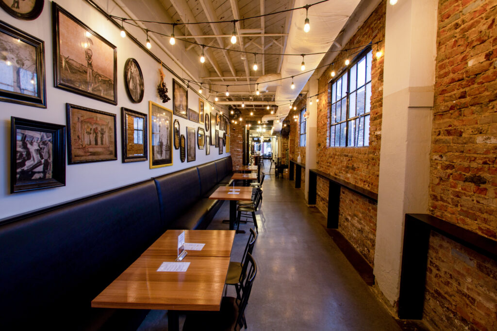 Maxwell's dining booths beneath framed artwork and exposed brick