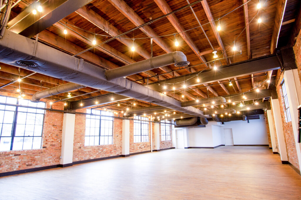 Event space with exposed brick, timber ceiling and festoon lighting at the Patrick Maxwell Building