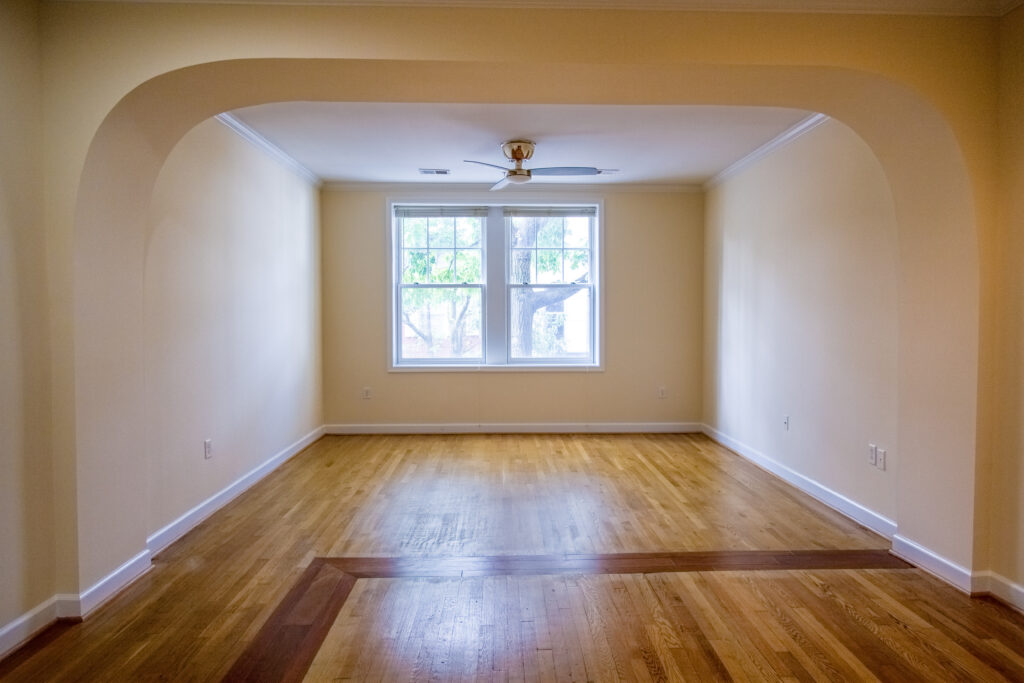 Renovated apartment living room with restored hardwood floors and street-facing windows