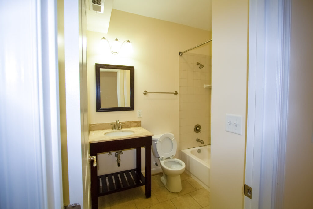 Renovated apartment bathroom with tub surround and vanity