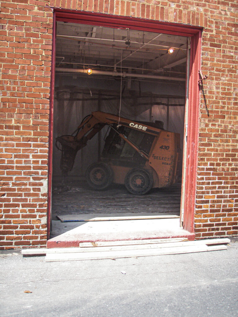 Brick facade with a new storefront opening framed during construction at the Patrick Maxwell Building